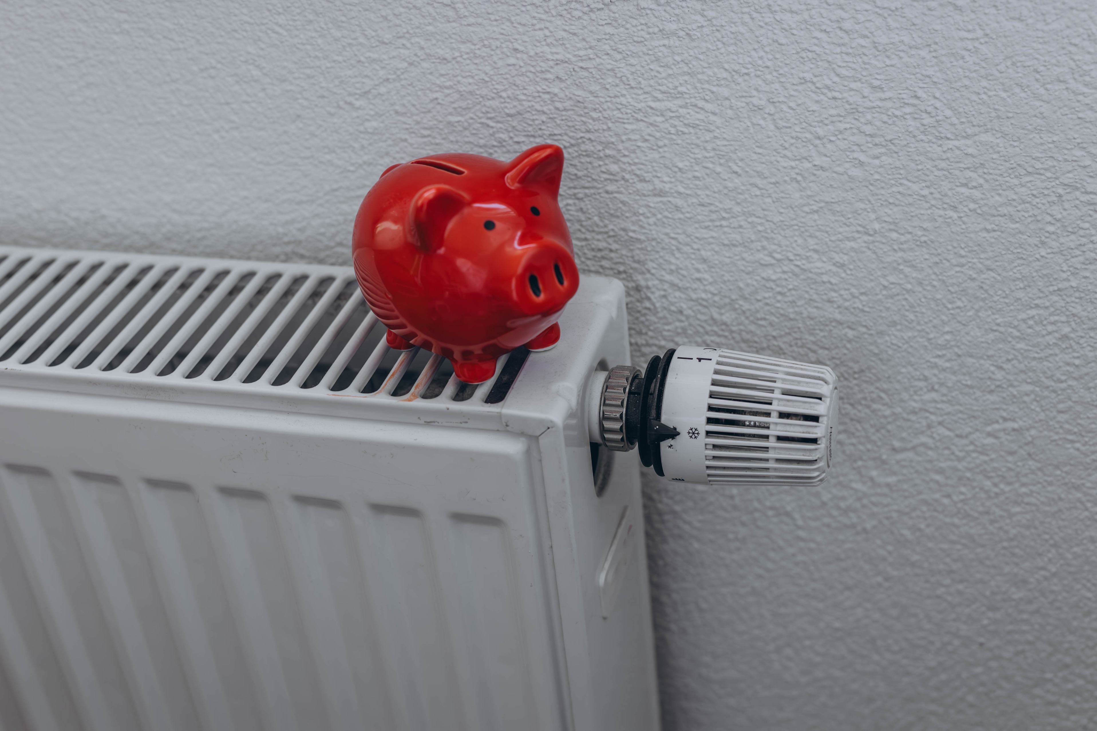 Piggy bank on a radiator, to illustrate saving money by reducing the amount of energy you use