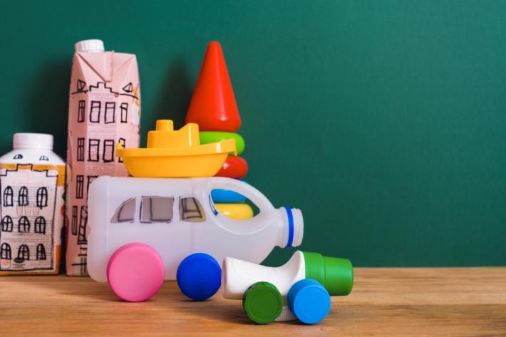 Milk and juice cartons that have been used to make toy cars and buildings