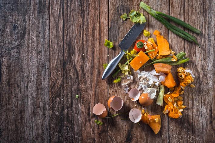 Left over food next to a chefs knife.