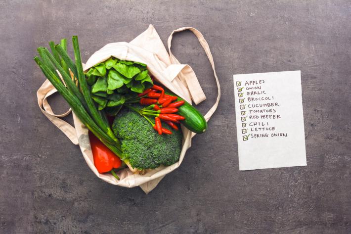 Shopping list and a bag with vegetables