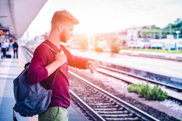 A man at the train station looking at his wristwatch