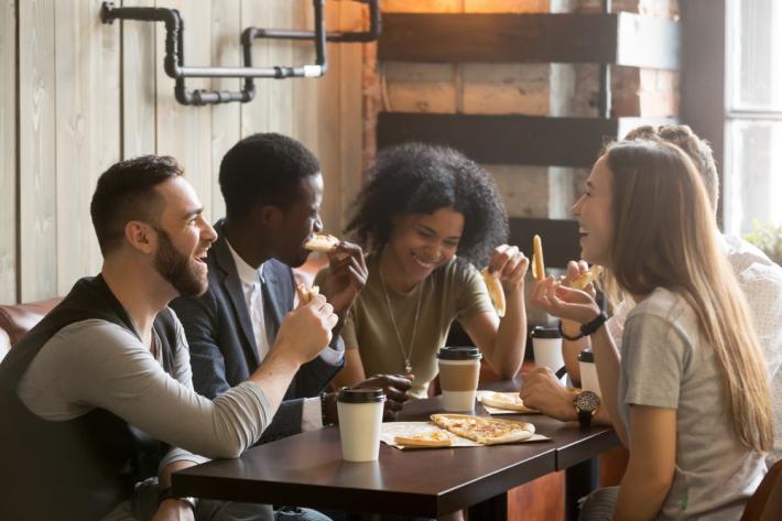 Young people laughing and chatting in a cafe