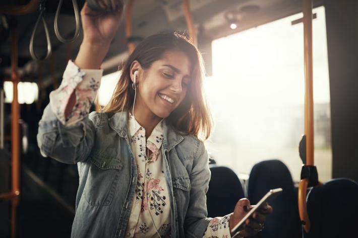 Woman on a bus listening to music