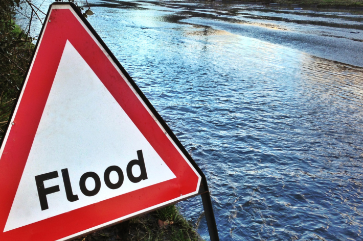 Overflowing river with Flood sign