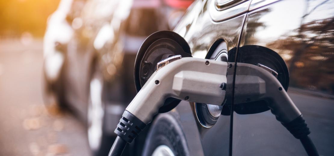 A close up of a plug charging an electric car