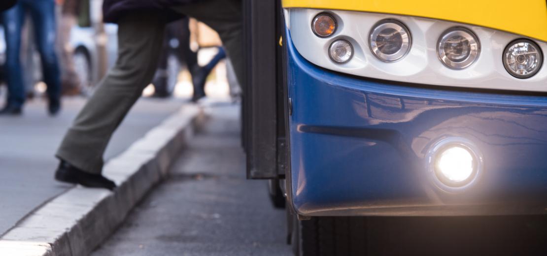 Someone stepping onto a blue and yellow bus