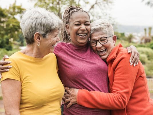 Three women embracing laughing